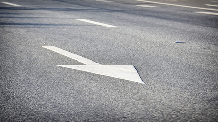 White arrow on asphalt road surface, transportation concept and keep moving idea