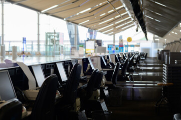 Row of empty check-in desks with computer monitors at the airport