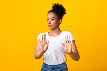 Serious black girl showing stop sign with two hands