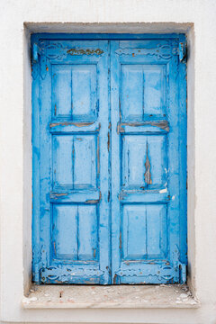 faded old rustic blue door on the island of Santorini Greece, traditional greek colours sunlight fade tourism greek islands