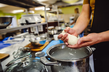 Italian hard cheese silano or caciocavallo in cheesemaker hands. The home-made cheese maker produces handmade caciocavallo. Concept: tradition, italy. The process of making mozzarella. Film noise.