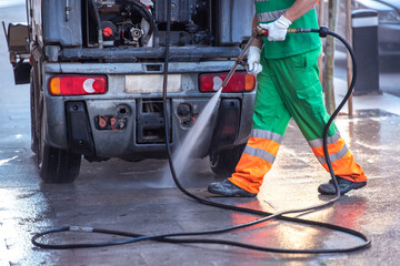 Person cleaning streets with a pressure gun