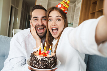 Cheerful attractive young couple celebrating birthday