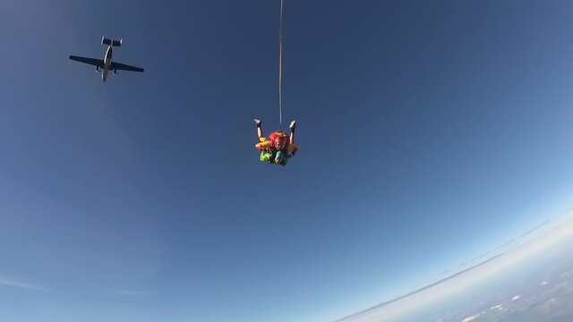 Tandem skydiving. A jumping out of a plane.  Happy girl and her instructor are falling in the sky.