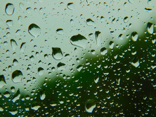 Fototapeta Krople letniego deszczu na szybie,  w tle las. obraz