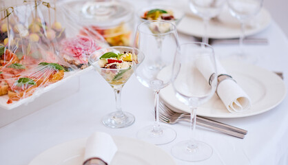 Beautiful festive table of luxury plates, glasses and cutlery served for wine tasting. Close up, blur background.