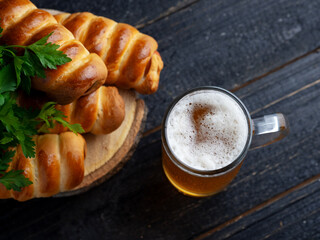 Wheat light beer in a mug glass and homemade sausages in a dough