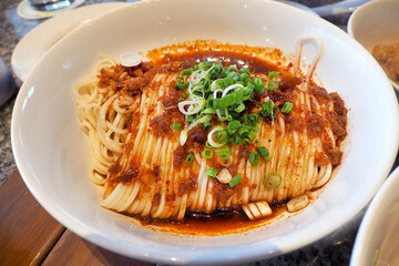 traditional Chinese spicy dried noodle topped with sichuan pepper sauce
