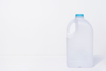Empty elastic milk gallon container on white background 