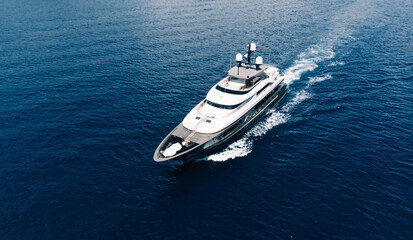 Aerial view of luxury yacht goes to open sea with beautiful blue colour of water. Wealth recreation...