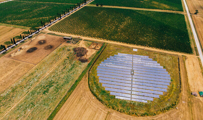 Fototapeta na wymiar Aerial top view of station with solar batteries in agricultural area near field. Alternative energy production system favorable to nature environment. Innovative biofuels photovoltaic technology
