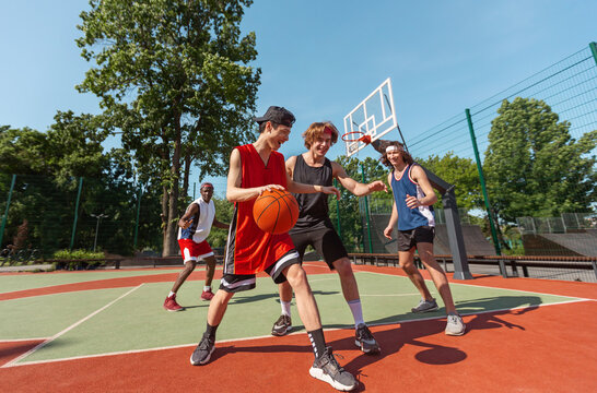 Group of young basketball players practicing game at outdoor sportsground - Powered by Adobe