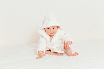 Baby less than a year old in a bathrobe after swimming