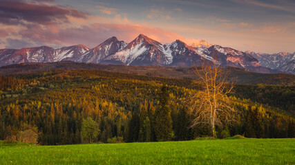 Spring in the Tatra Mountains. Green fields against the backdrop of snowy peaks. Landscape photo from Lesser Poland.