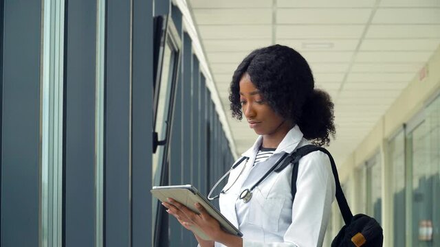 African american woman student intern with a tablet in the hospital. New modern fully functional medical facility. Concept of medicine, health care and people, online education