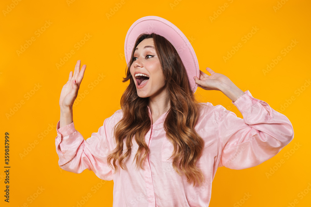 Canvas Prints image of attractive excited woman in hat waving hand and looking aside