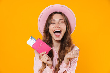 Image of delighted woman holding passport with ticket and laughing