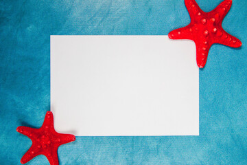 Red starfishes with the blank paper page on a blue background