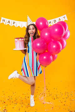 Image of excited woman posing with pink balloons and birthday torte
