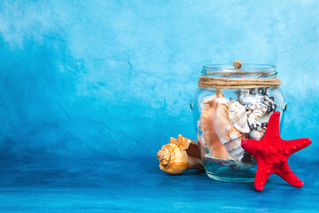 Jar full of seashells with the starfish on a blue background
