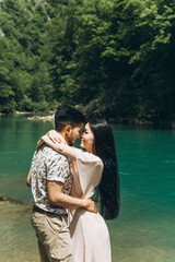 Young couple in the nature. A man hugs a woman. They are going to kiss.