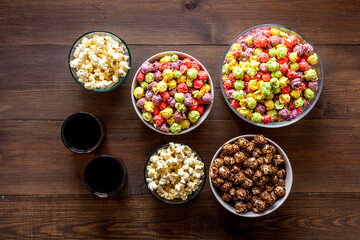 Set of flavored popcorn and soda on wooden table top view