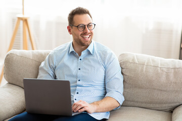 Young man sitting on couch and looking aside