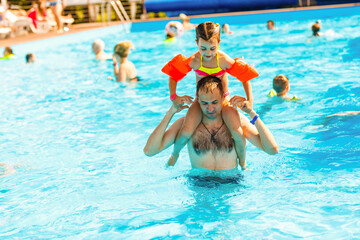 Father playing with his daughter in swimming pool