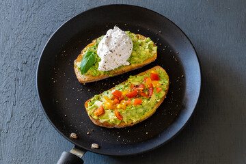Tasty sandwich with poached egg, avocado and tomatoes