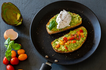 Tasty sandwich with poached egg, avocado and tomatoes