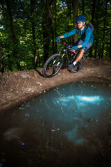 Biker in blue clothes leaning in a curve in the forrest