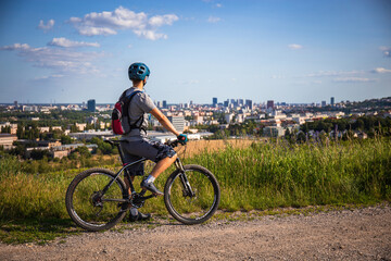 Mountain biker looking on a city from a hill