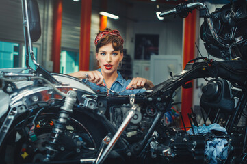 beautiful girl repairs a motorcycle in a workshop, pin-up style, service and sale