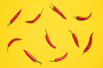 Flat lay red chili peppers pattern on yellow background. Top view