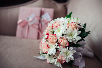 Wedding bouquet of roses and chrysanthemums on a background of pink certificates