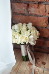 Wedding bouquet of white roses on a brick wall background