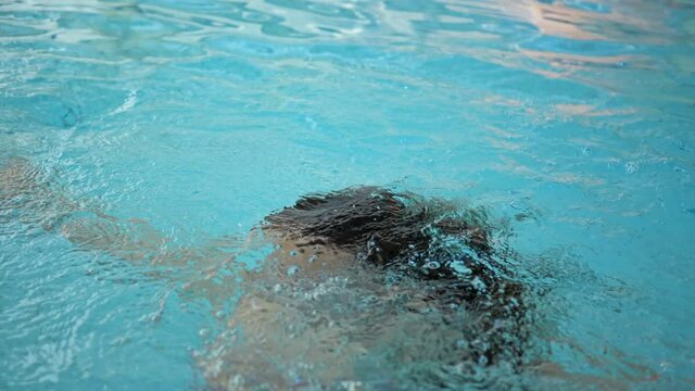 Young woman drowning in the pool. Female cannot swim and drowns in water