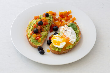 Tasty sandwich with poached egg, avocado and tomatoes