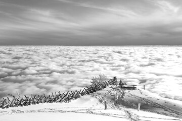 Above the clouds. View from the mountain of Riga, Switzerland. Meditation bench on top of a mountain. Black and white photo.