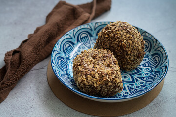 Bomboloni coated with oats. Donut filled with melted chocolate and eaten as a snack. Bomboloni originated from italy.