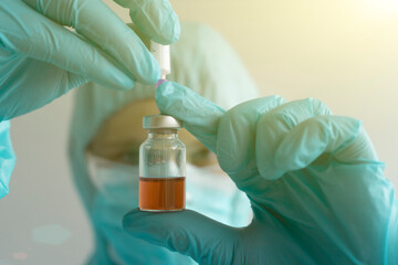 Development of a vaccine, the doctor holds an ampoule in his hand
