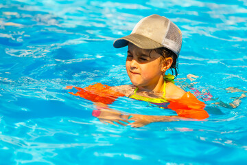 Cute toddler girl playing in swimming pool