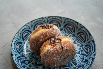 Bomboloni, a donut filled with melted chocolate and eaten as a snack. Bomboloni originated from italy.