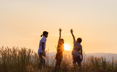 children playing on mountain at sunset background