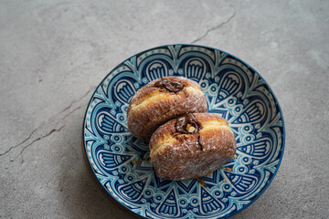 Bomboloni, a donut filled with melted chocolate and eaten as a snack. Bomboloni originated from italy.