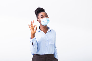 Young woman wearing medical face mask, studio portrait. Woman Wearing Protective Mask and Showing OK sign. Woman wearing surgical mask for corona virus