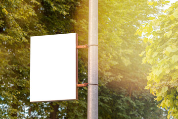 The blank advertising banner suspended on the street lamp pole - obrazy, fototapety, plakaty