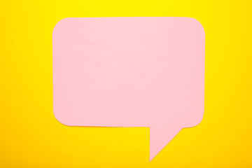 Pink paper speech bubbles on yellow background