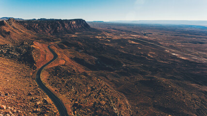 Aerial view of beautiful rocky mountain range with an asphalt road highway running along. Bird's eye scenery view red cliff in area of desert landscape of United states