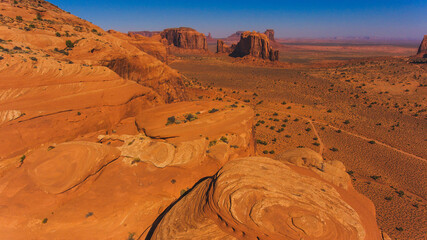 Bird's eye view of beautiful nature Monument Valley landmark of Arizona state. Aerial scenery view of wild lands at sunny day. High cliffs and endless sand desert © BullRun